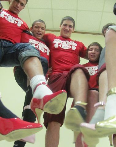Football team volunteers to walk a mile in womens shoes to raise awareness about violence against women