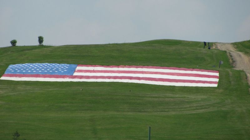 Giant flag overlooks green as veterans are honored at golfing event to benefit Walter Reed Hospital