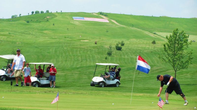 Giant flag overlooks green as veterans are honored at golfing event to benefit Walter Reed Hospital
