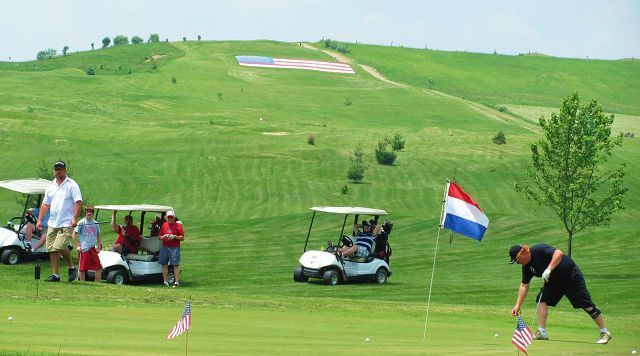 Old Glory overlooks green as veterans are honored at golfing event