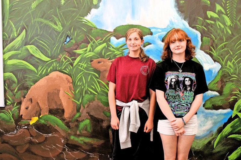 Students paint rainforest mural in classroom